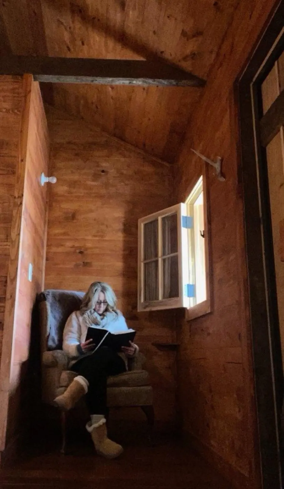 Reading by the window in a cabin
