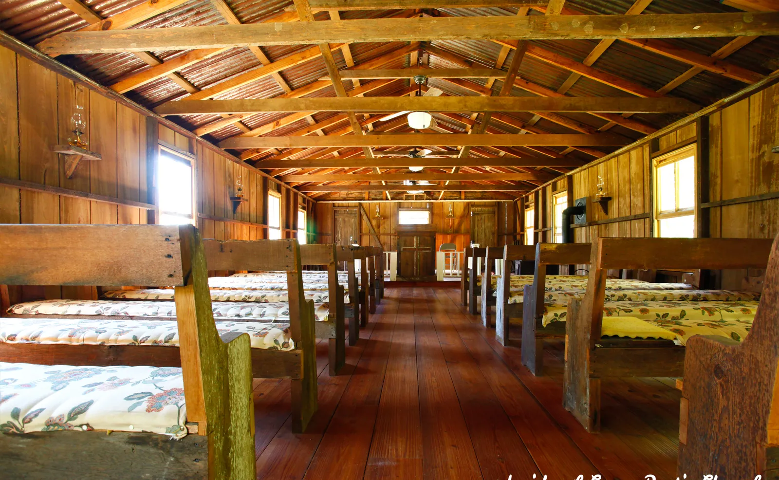 Inside the rustic chapel — wooden pews and warm light