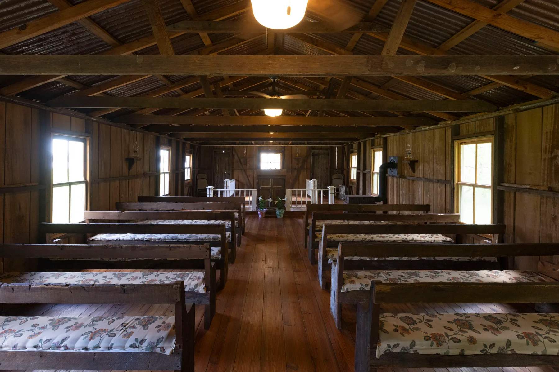 The chapel interior — wooden pews beneath an open timber roof