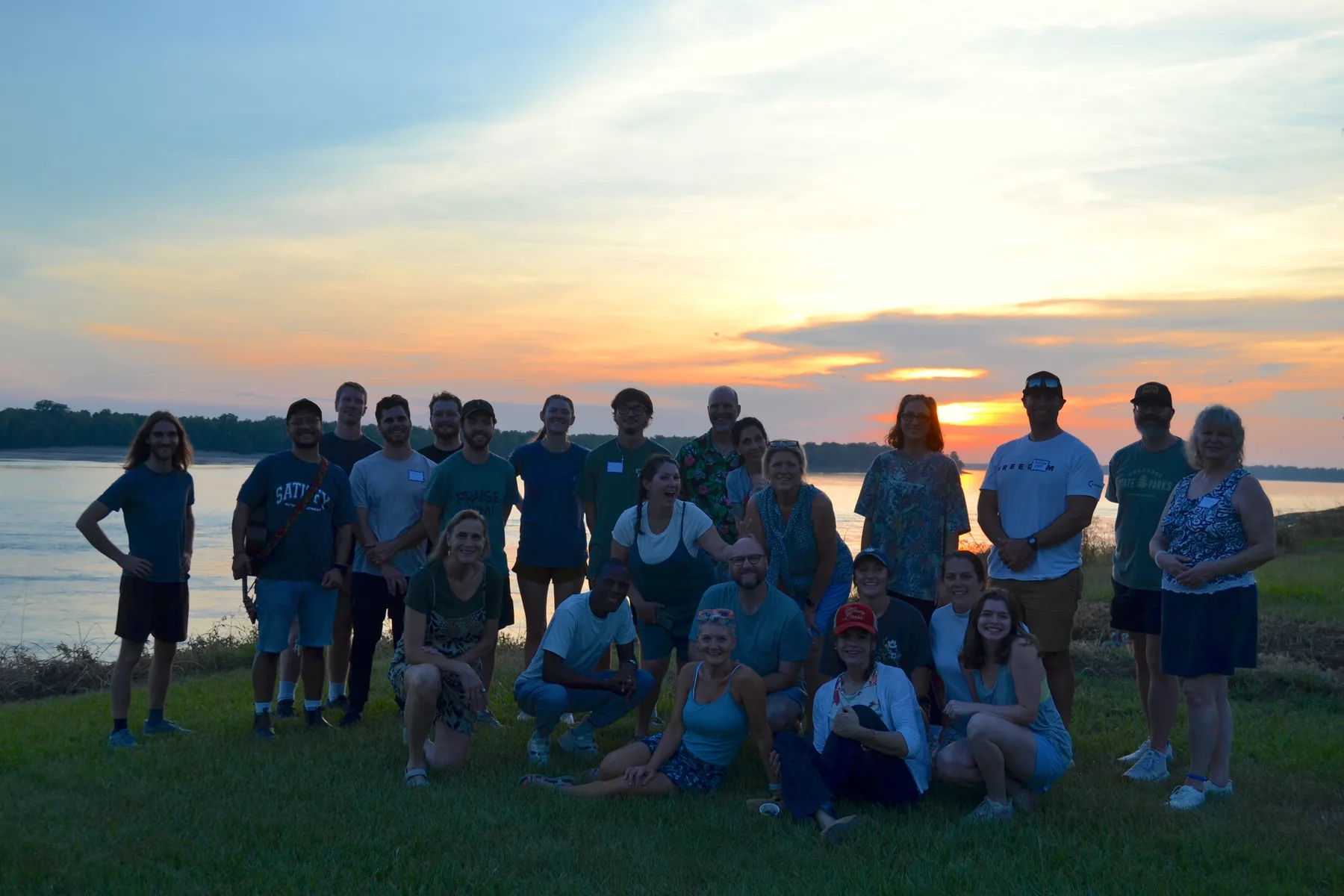A retreat group together at sunset by the river