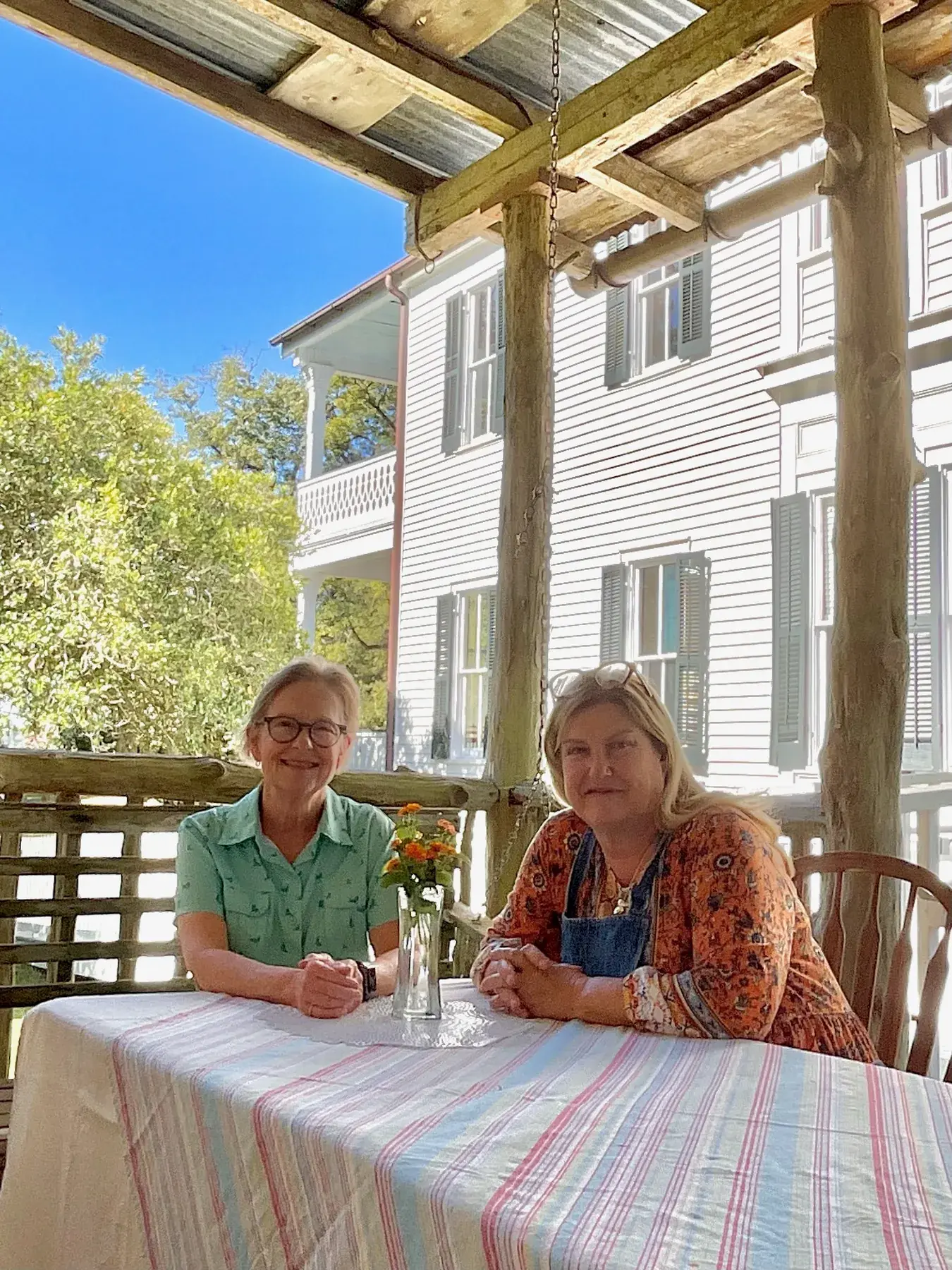 Two guests at a table on the home's porch