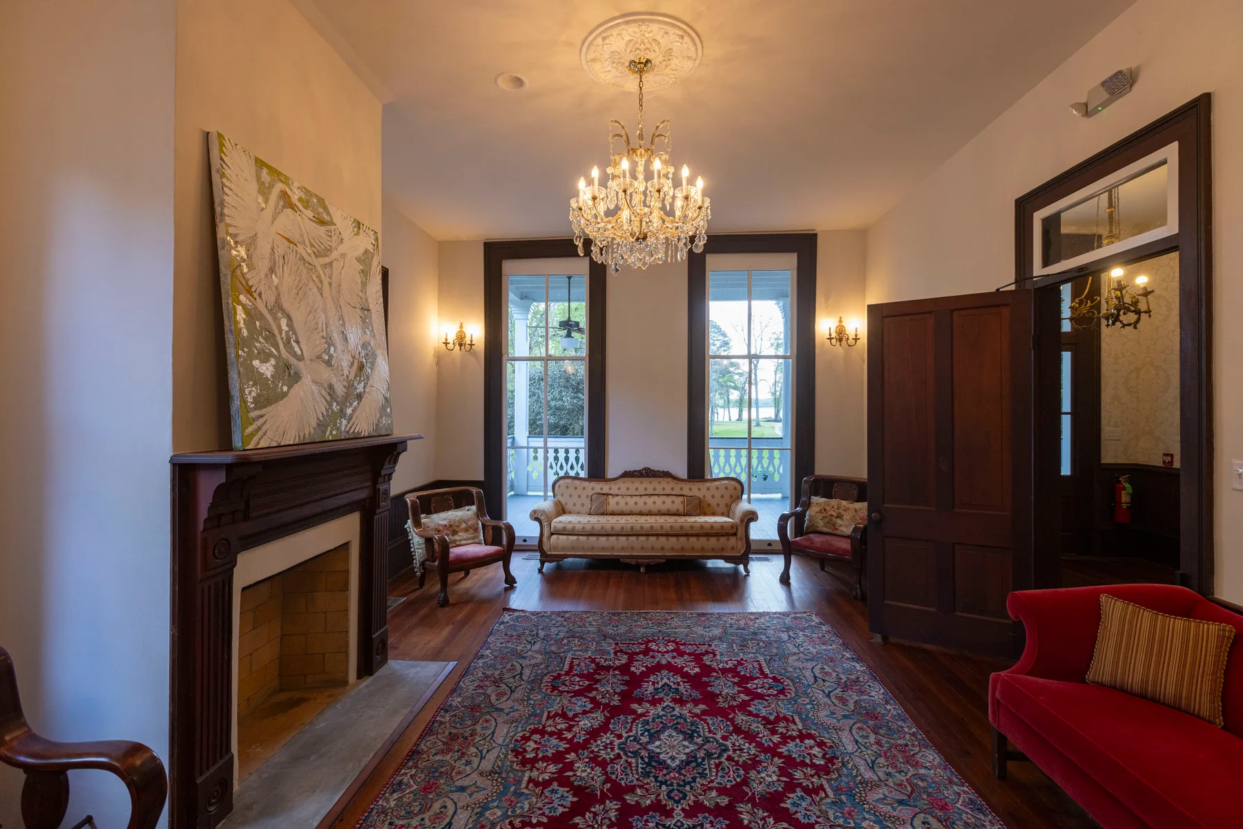 The parlor, with chandelier, fireplace and period furnishings